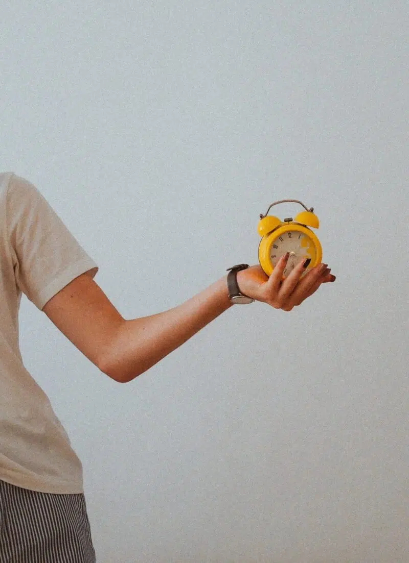 Frau hält einen Wecker
