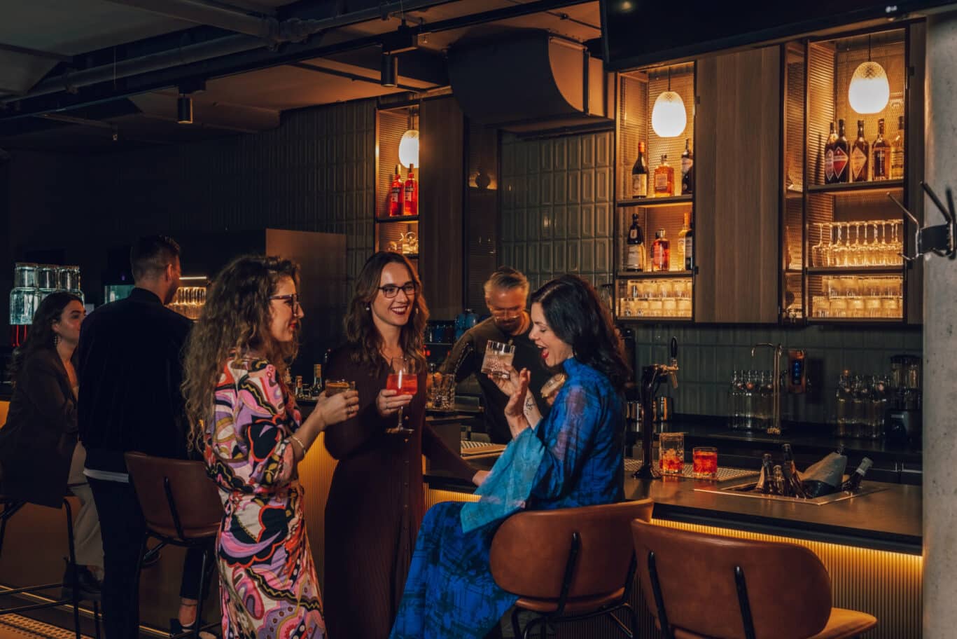 Hotelgäste die an der hoteleigenen Bar zusammen trinken und sprechen