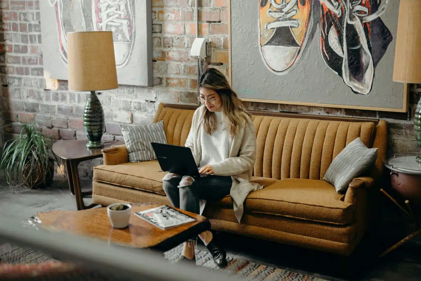 woman using laptop while sitting on couch